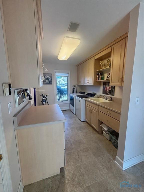 kitchen featuring a sink, light countertops, open shelves, and washer and clothes dryer