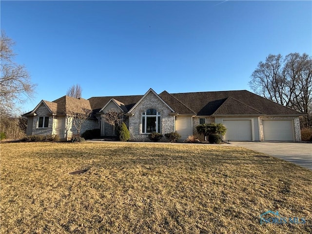 single story home with driveway, a front lawn, and an attached garage