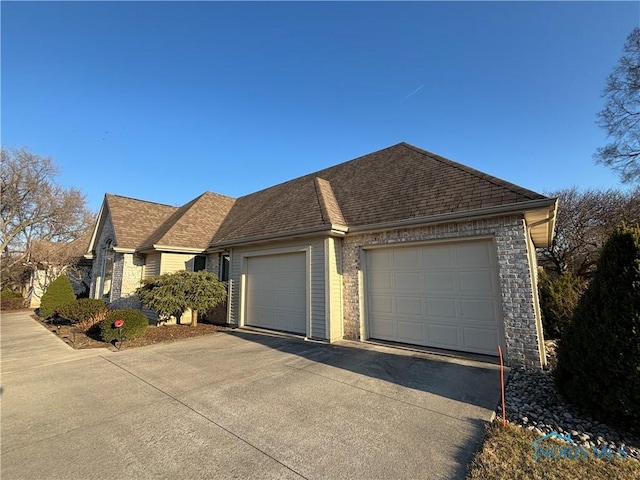 view of front of property with a garage and a shingled roof