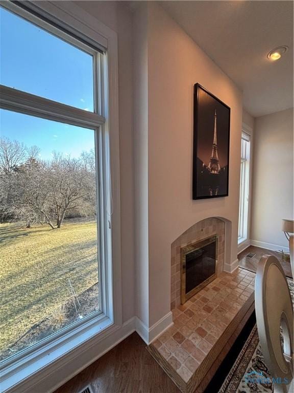 living room with baseboards, plenty of natural light, and a tile fireplace