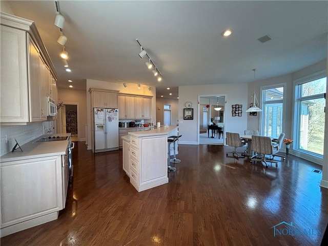 kitchen with a breakfast bar, light countertops, dark wood finished floors, and stainless steel appliances