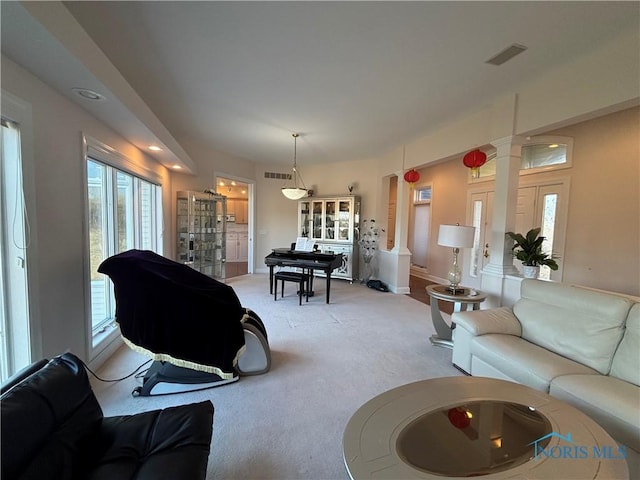 living room with visible vents, light colored carpet, and ornate columns