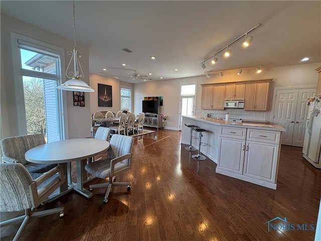 dining space featuring recessed lighting, baseboards, and dark wood-style flooring