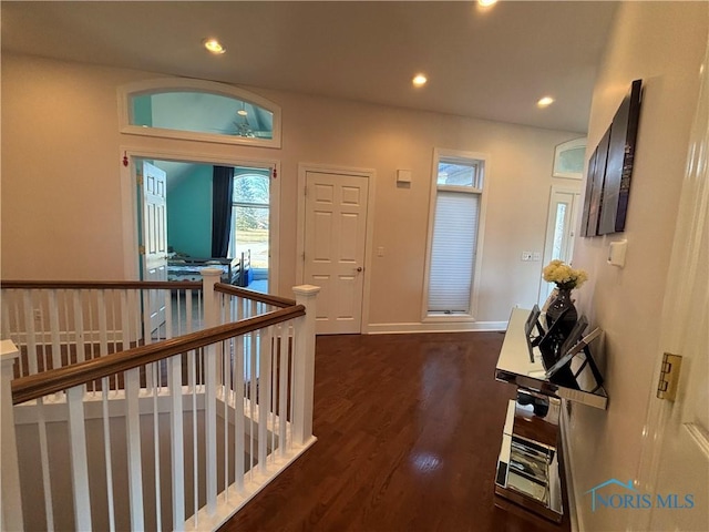 hall with recessed lighting, wood finished floors, baseboards, and an upstairs landing