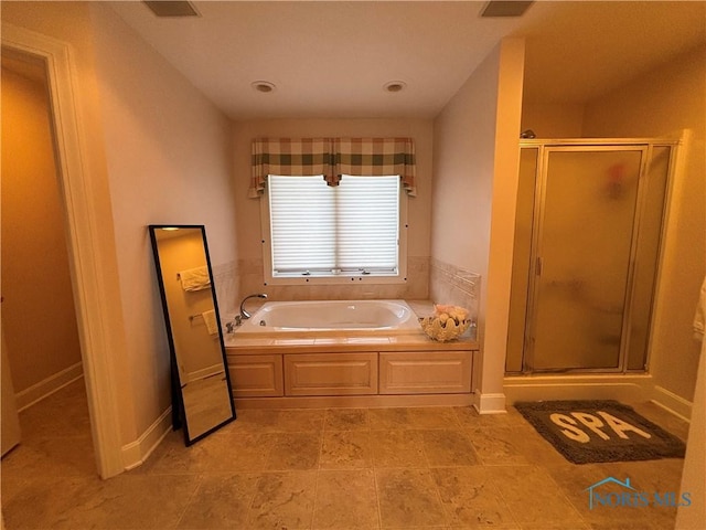 full bath featuring a shower stall, baseboards, and a garden tub