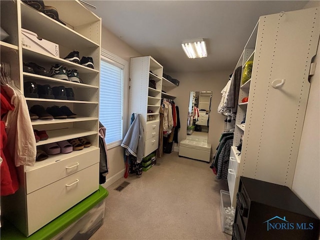 walk in closet with visible vents and light carpet