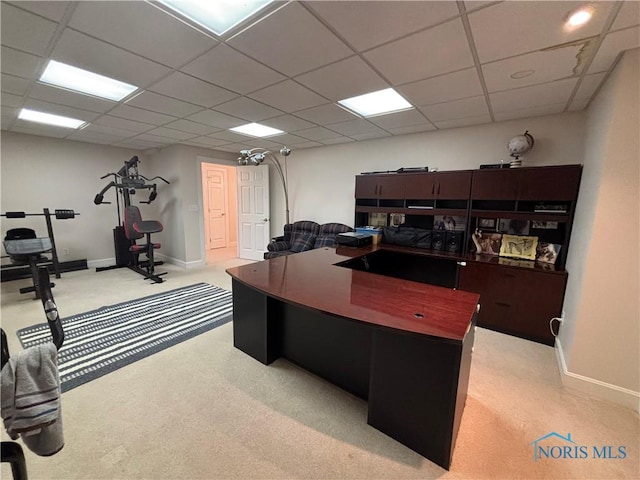 carpeted home office with a drop ceiling and baseboards