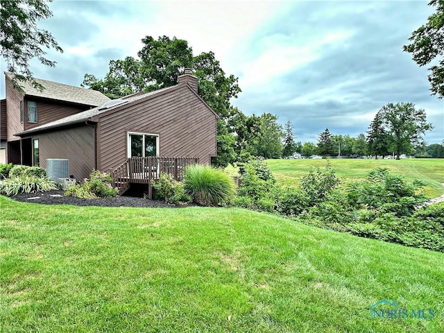 view of yard featuring central air condition unit and a wooden deck