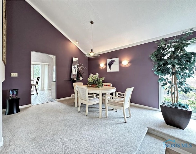 dining room with high vaulted ceiling, baseboards, and carpet floors