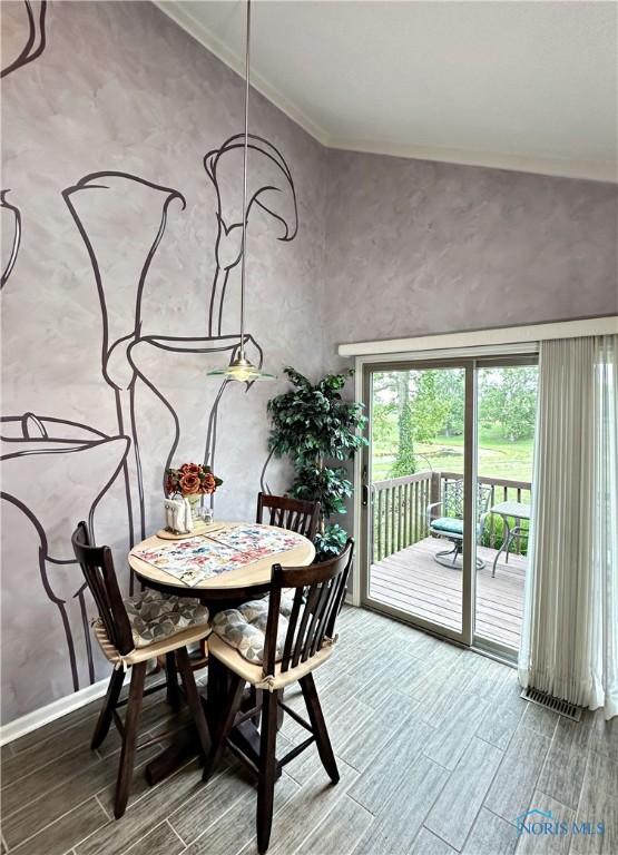 dining room with ornamental molding and wood tiled floor