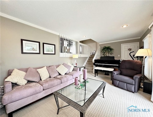 living area with carpet flooring, a textured ceiling, ornamental molding, and stairs