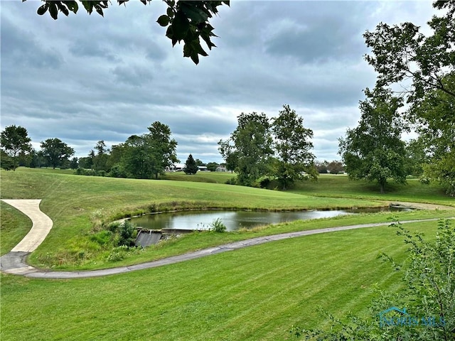 view of property's community with a lawn and a water view