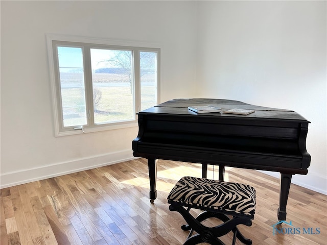 sitting room with baseboards and wood finished floors