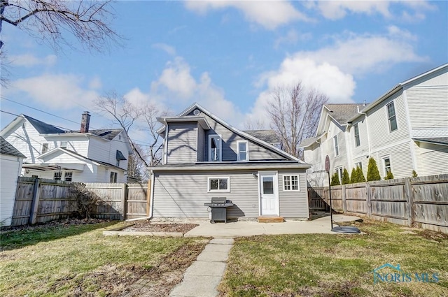 back of house featuring a patio, a lawn, and a fenced backyard