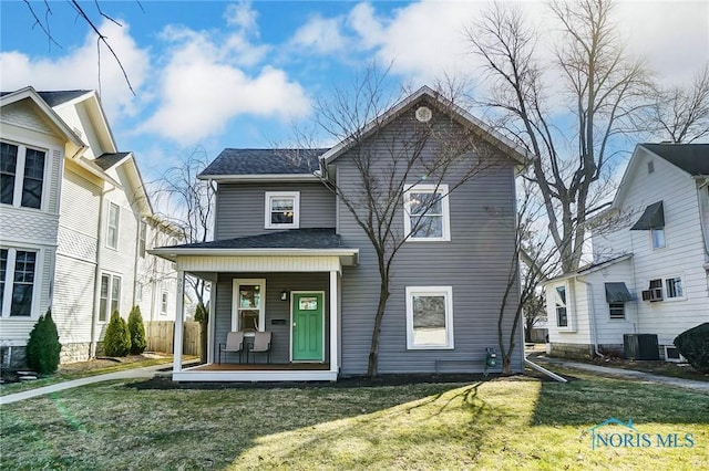 view of front of house with central AC unit, a porch, a front yard, and roof with shingles