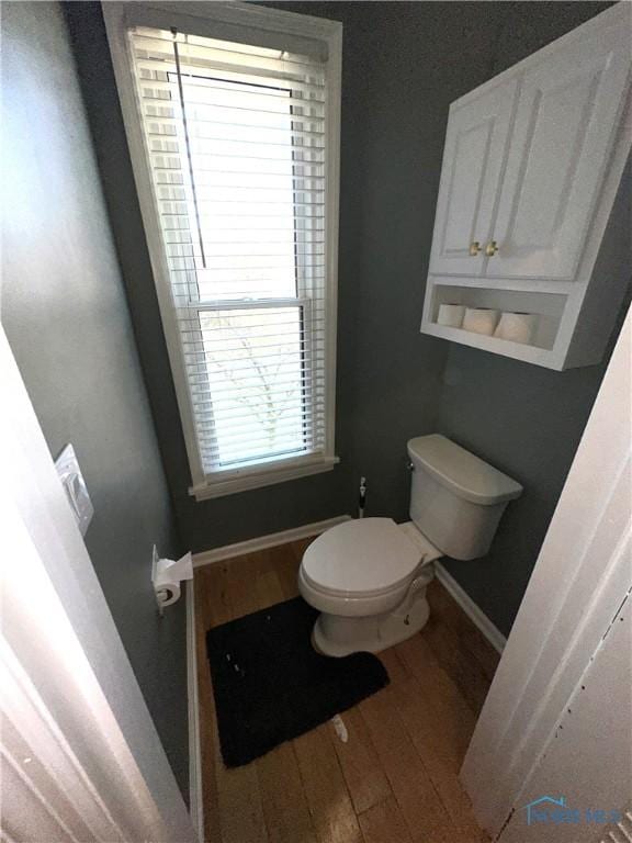 bathroom featuring toilet, baseboards, and wood finished floors