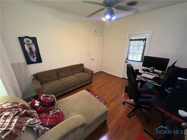 office space featuring ceiling fan, visible vents, and wood finished floors