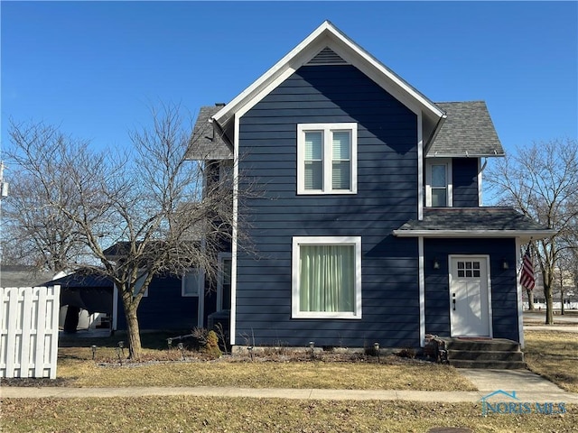 view of front of house featuring fence and roof with shingles