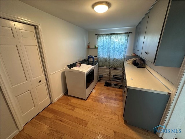 washroom featuring laundry area, baseboards, light wood finished floors, and washer / dryer