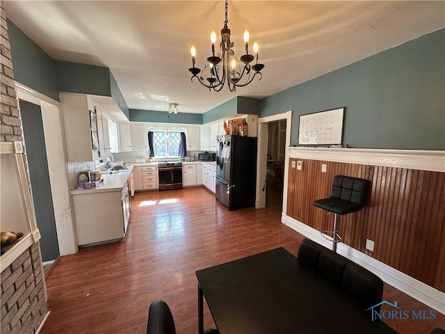 kitchen with dishwashing machine, dark wood-style floors, freestanding refrigerator, light countertops, and black microwave