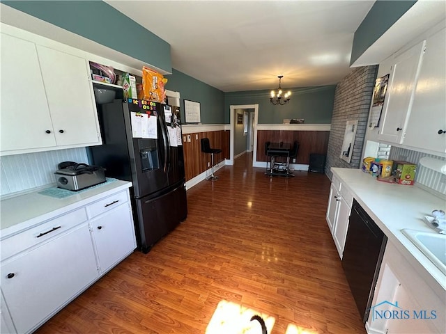 kitchen featuring an inviting chandelier, light wood-style flooring, black appliances, light countertops, and white cabinetry