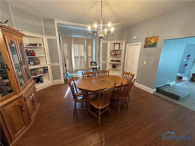 dining room with dark wood finished floors, a chandelier, built in shelves, and baseboards