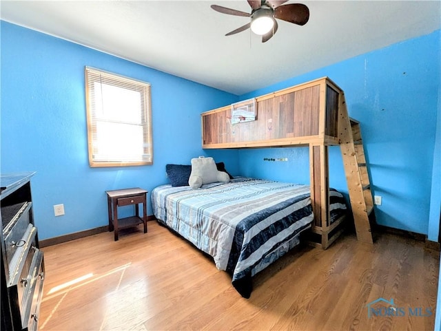 bedroom with light wood-style flooring, baseboards, and ceiling fan