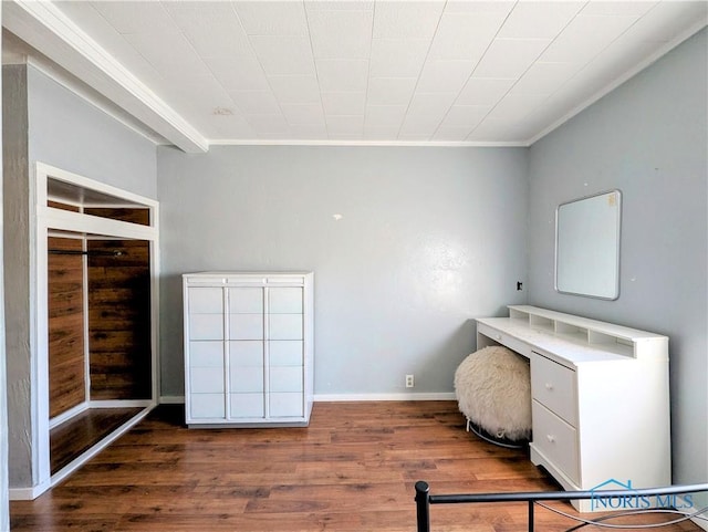 interior space featuring baseboards, wood finished floors, and crown molding