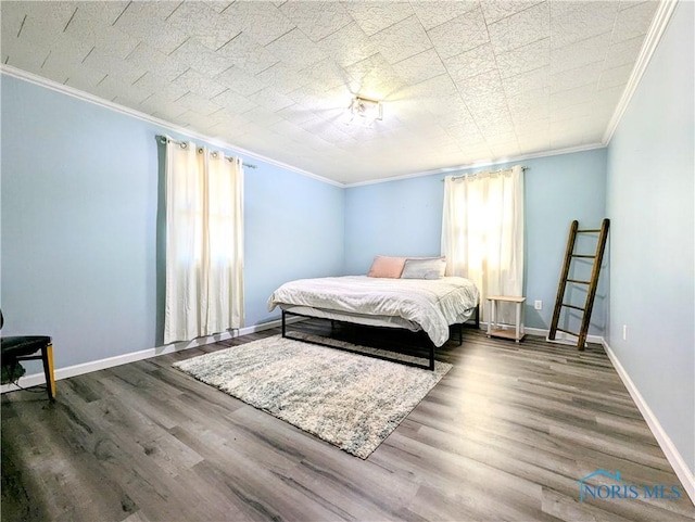 bedroom with wood finished floors, baseboards, and ornamental molding