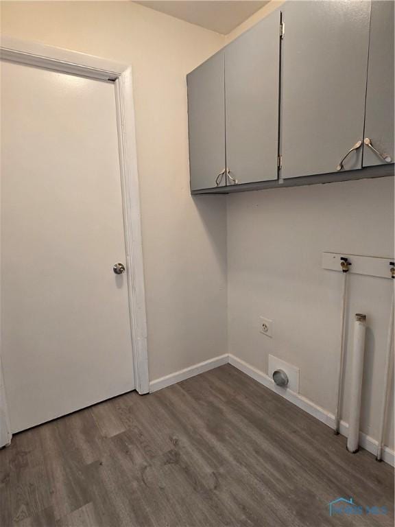 laundry room with baseboards, cabinet space, hookup for an electric dryer, and dark wood-style floors