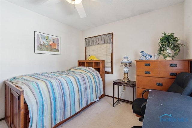 bedroom featuring light carpet, a ceiling fan, and baseboards