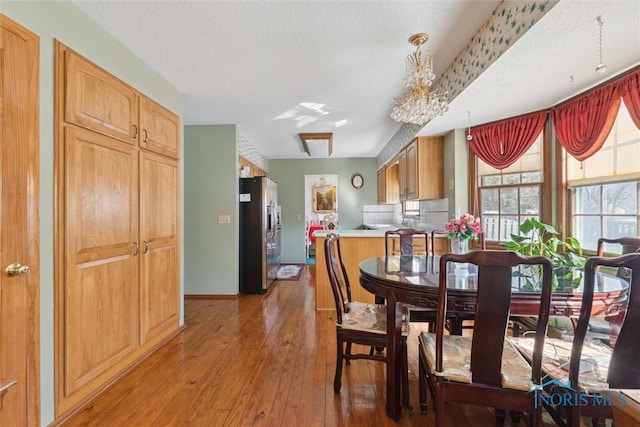 dining room with a textured ceiling and wood-type flooring