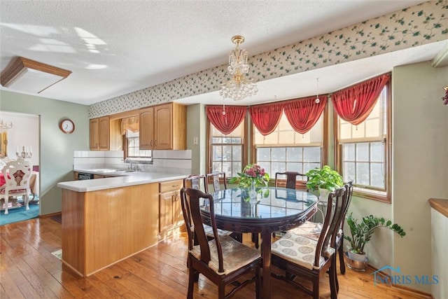 dining area with a textured ceiling and light wood-style flooring