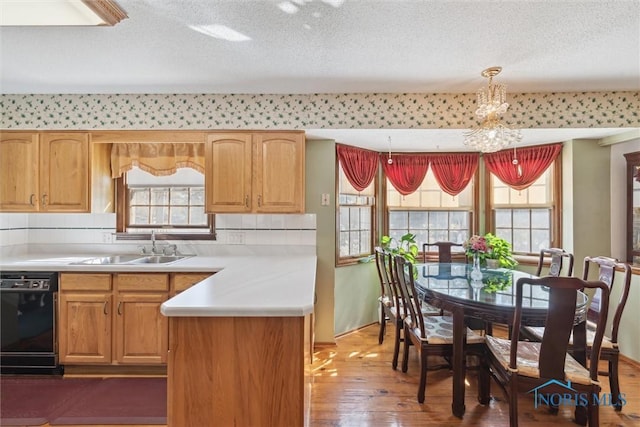 kitchen with tasteful backsplash, dishwasher, light countertops, wood finished floors, and a textured ceiling