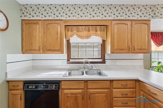 kitchen featuring dishwasher, light countertops, backsplash, and a sink