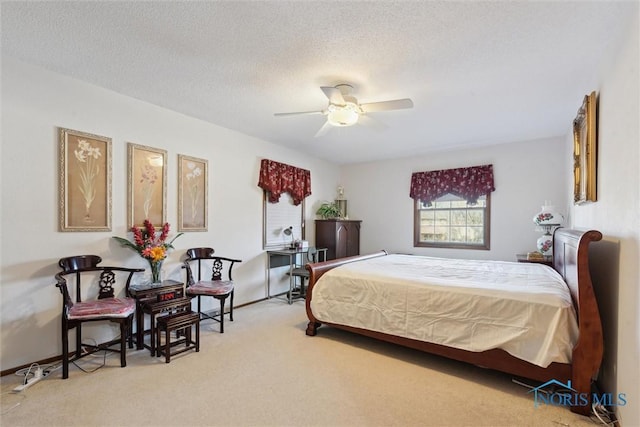 bedroom with ceiling fan, carpet flooring, and a textured ceiling