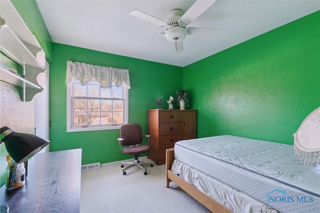 bedroom with baseboards, visible vents, carpet floors, ceiling fan, and a textured ceiling