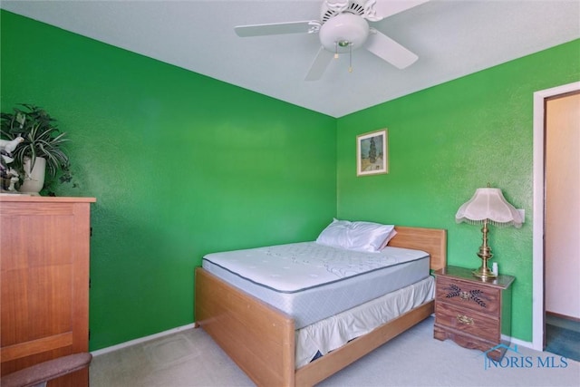 carpeted bedroom featuring baseboards and a ceiling fan