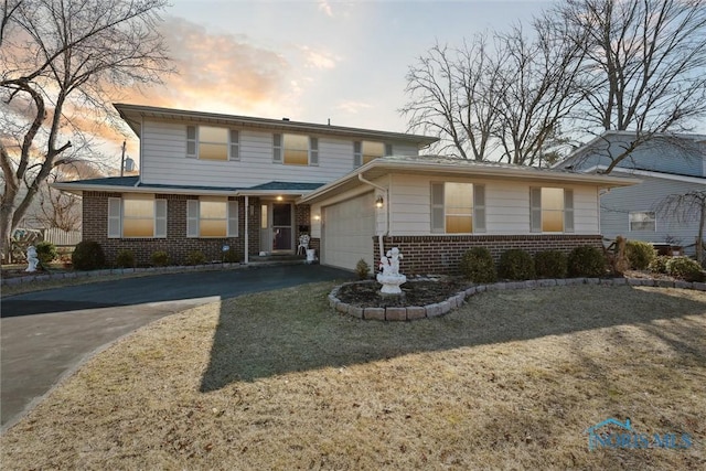 traditional-style home featuring brick siding, driveway, and an attached garage