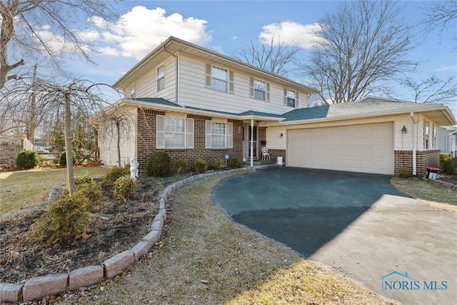 traditional-style home with aphalt driveway, brick siding, and a garage