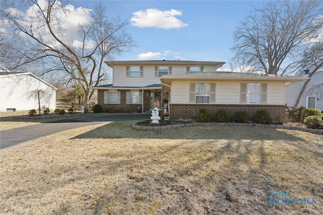 traditional-style home with a front yard and brick siding