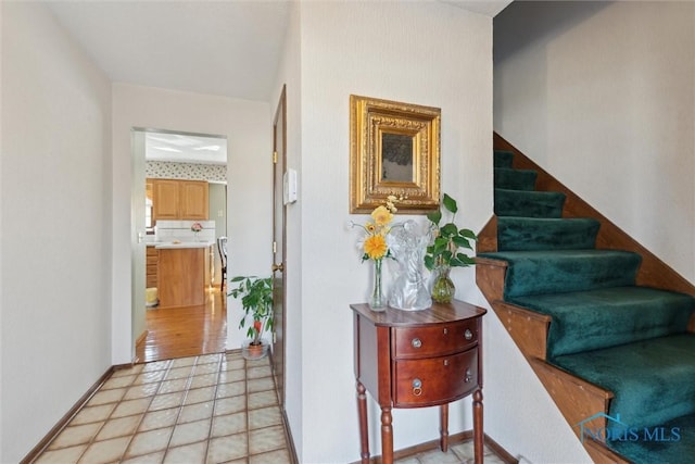 stairs with wallpapered walls and baseboards