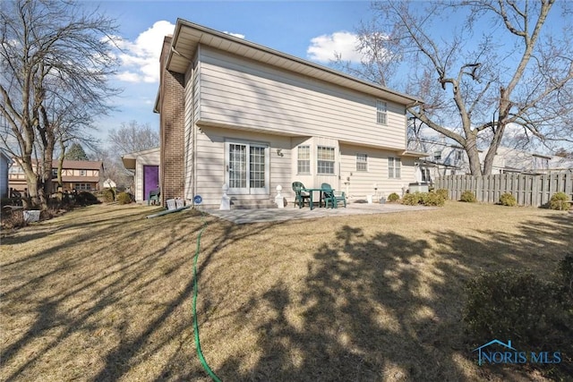 rear view of house with a patio, entry steps, a yard, and fence