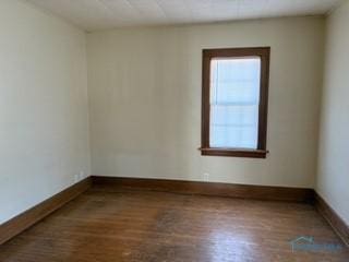 spare room with wood finished floors and baseboards