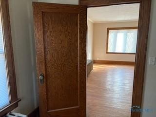 hallway featuring baseboards and wood finished floors