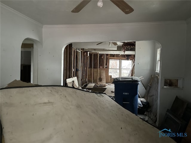 interior space featuring arched walkways, crown molding, and ceiling fan