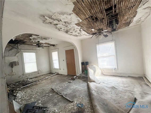 spare room with arched walkways and ceiling fan