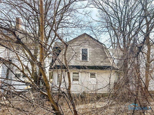 view of property exterior with a gambrel roof