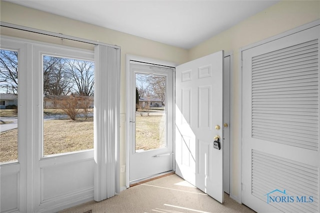 doorway featuring light colored carpet