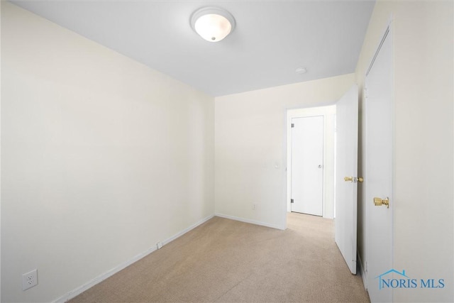 empty room with baseboards and light colored carpet